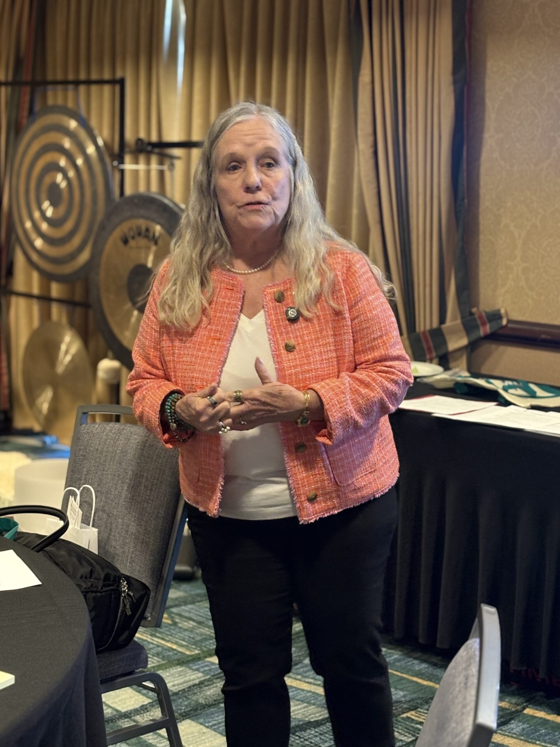 Dianne Allen guiding a retreat experience with therapeutic gongs behind her